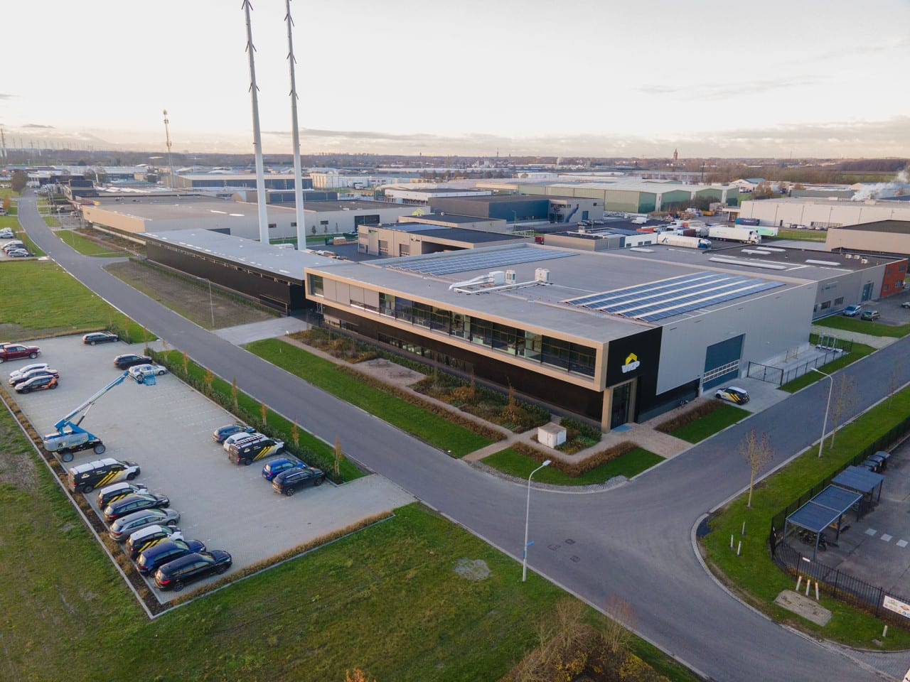 Luchtfoto van de productielocatie van VKP met kantoor, productiehallen en zonnepanelen op het dak.